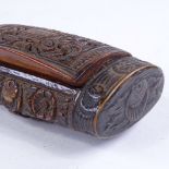 A 19th century coquilla nut snuffbox, all over relief carved musical instruments in floral border,