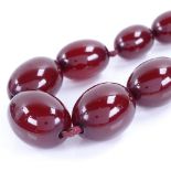 A single-strand graduated cherry amber bead necklace, beads measuring from 10.5mm to 24.5mm,