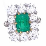 A rectangular emerald and diamond cluster ring, early 20th century, central emerald step-cut emerald