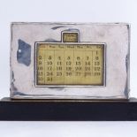 An early 20th century silver-fronted perpetual desk calendar, on wood frame, by W J Myatt & Co,