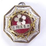 A religious reliquary pendant in unmarked metal filigree surround, 32mm across, leather case