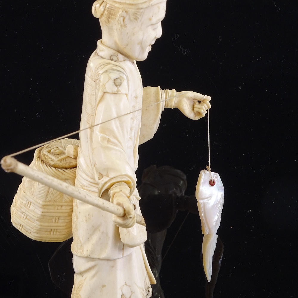 A Japanese ivory okimono depicting a fisherman with a mother-of-pearl fish, Meiji Period, height - Image 2 of 3