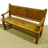 A 19th century golden oak hall settle, with linenfold carved and panelled back, length 142cm