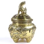 A Chinese polished bronze incense burner and cover, with dragon knop and relief moulded dragon