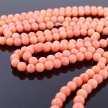 A long strand of polished pink coral beads, bead diameter 5.4mm, overall length 120cm, 54.3g