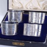 A set of 4 George VI silver napkin rings, engraved Art Deco style designs, by Walker & Hall,