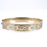 A mid-20th century 9ct gold hinged bangle, engraved foliate decoration, hallmarks Birmingham 1961,