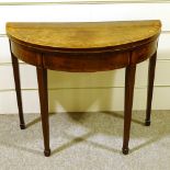 A George III mahogany demilune fold over card table, with tapered legs and spade feet