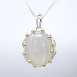 A large unmarked silver and gilt cabochon moonstone pendant, open wirework settings, pendant