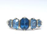 A 9ct gold graduated 5-stone blue topaz half hoop ring, set with oval cut topaz and engraved