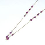 An 18ct gold ruby line necklace, set with pear-cut rubies, necklace length 45cm, 2.7g Very good