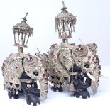 A 19th century graduated pair of unmarked silver and ebony gem-set caprisoned elephants, with Howdah