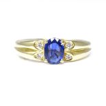 An 18ct gold Ceylon sapphire and diamond dress ring, set with oval cut sapphire and round cut