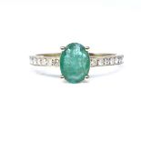 A 14ct gold solitaire emerald ring, with diamond set shoulders, oval-cut emerald approx 0.71ct,