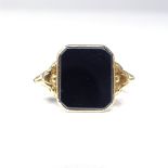 A Swedish 18ct gold polished hematite panel signet ring, relief scrollwork shoulders, hallmarks