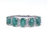 A 14ct white gold emerald and diamond half-hoop ring, total oval-cut emerald content approx 1.