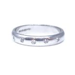 A platinum 5-stone diamond wedding band ring, bezel-set with round brilliant cut diamonds, total