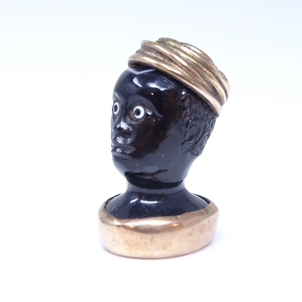 A 19th century banded agate figural Blackamoor seal fob, unmarked rose gold mounts with cabochon