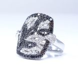 An 18ct white gold black and colourless diamond cluster cocktail panel ring, with pierced marquise