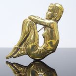 A large Art Deco Danish brass figural brooch, depicting a seated girl with a cap, signed Christie,