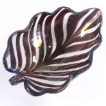 TYRA LUNDGREN FOR VENINI - a 1930s thick Murano glass leaf bowl, amethyst coloured stripes with wave