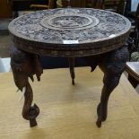 An ornate relief carved Indian hardwood circular table, on elephant supports, W41cm, H41cm