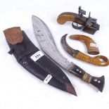A Dunhill Tinder pistol (missing front legs), a horn-handled kukri knife, and a small Middle Eastern