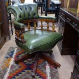 A studded green leather-upholstered swivel desk chair, on mahogany splayed leg base