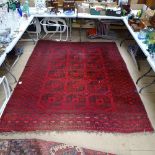 A red ground Afghan rug, with Gul lozenge and symmetrical border, 175cm x 135cm