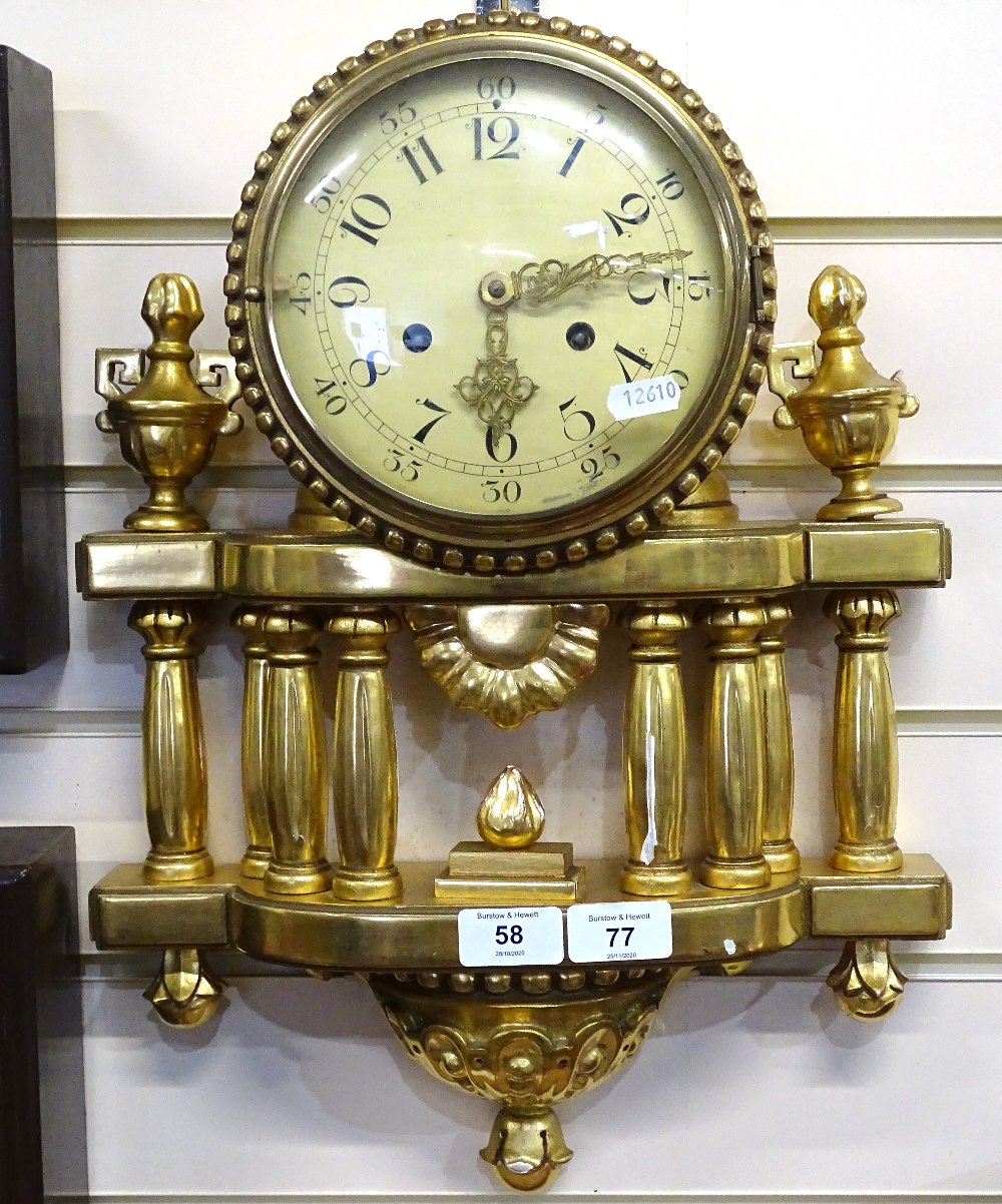 An ornate carved giltwood-cased wall clock, with fluted columns and brass 8-day striking movement,