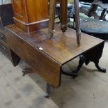 A 19th century mahogany drop leaf breakfast table, raised on turned centre column and reeded sabre