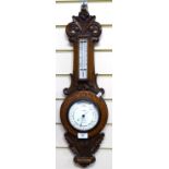An oak-cased aneroid barometer and thermometer, with floral carved cased, height 62cm