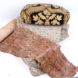A Paisley printed backed bed cover, a bolster cushion, and a roll of snakeskin (3)