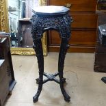 A Chinese hardwood jardiniere stand, having an inset marble top, with ornate carved and pierced