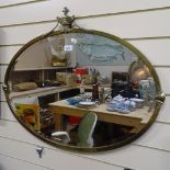 Early 20th century brass-framed oval wall mirror, surmounted by an urn, 80cm across