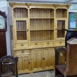 A large polished pine 2-section dresser, top fitted with glazed doors and open shelves and fitted