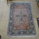 A Persian silk and wool rug with salmon ground, 185cm x 125cm