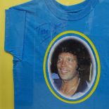 A framed tee shirt, bearing a portrait print of Tom Jones, signed by him in the BBC Green Room 2002