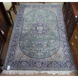 A green ground Persian design rug, 220cm x 145cm