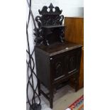 A 1920s oak cabinet, with raised carved panelled shelf back, and cupboards under, W62cm, H150cm,