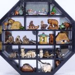 An octagonal wall-hanging display cabinet, with sectional interior and mirrored back, containing