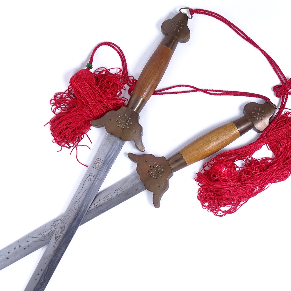 A pair of Chinese swords in single brass-bound wood scabbard, with brass and wood handles, overall