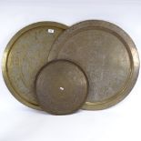 2 Eastern engraved brass trays/table-tops, with figure and script decoration, largest 70cm, and a