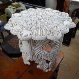 An ornate relief carved table of shaped form, on a pierced folding base, W60cm, H53cm