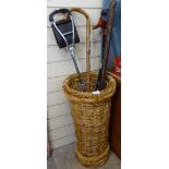 A wickerwork stick stand, containing various sticks, including African examples and shooting stick