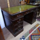 A reproduction mahogany twin-pedestal writing desk, with green leather skiver and fitted drawers,