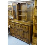 A modern carved and panelled oak 2-section dresser, W133cm, H181cm, D46cm