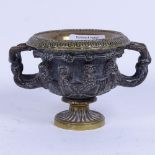 A small 19th century patinated bronze Classical urn, the frieze decorated with masks, rim diameter