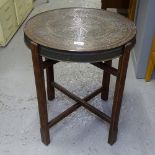 A Middle Eastern engraved brass-top table on folding base, W50cm, H60cm