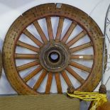 A large Antique heavy wooden gun carriage wheel with steel rim and studwork decoration, H205cm